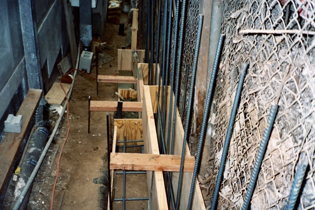 Concrete poured to hill side step forms Hillside retaining wall footing forms