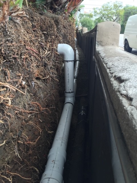 French drain T connection discharge location, base of planter wall