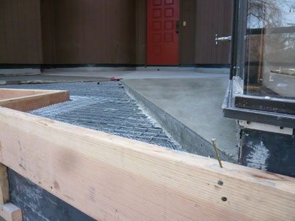 Sloping mortar bed applied directly over courtyard deck drainage panels