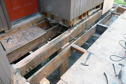 Temporary support positioned under termite damaged courtyard deck structural beam